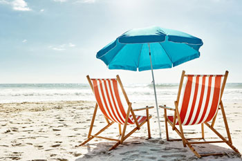 Liegestühle und Sonnenschirm am Strand