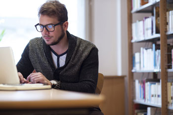 junger Mann an Schreibtisch mit Computer