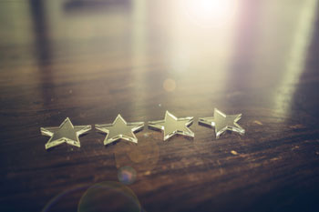 Vier Sterne liegen auf einem braunen Holztisch